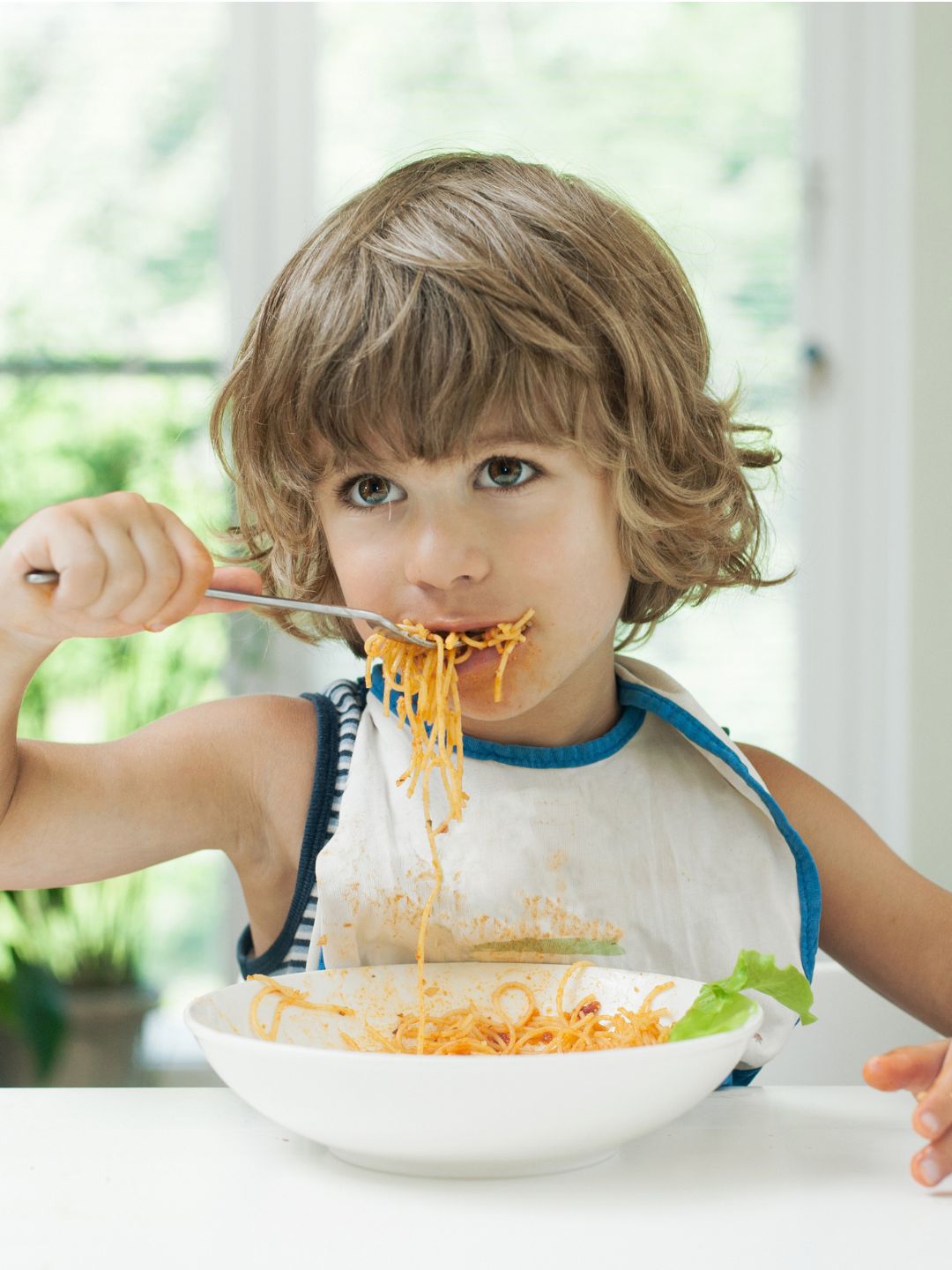 Niña comiendo espagueti